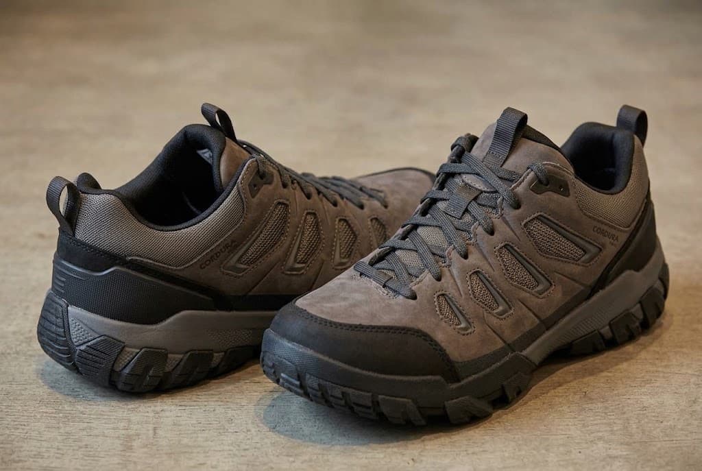 A pair of brown low-cut hiking shoes with black toe protection and dark laces.